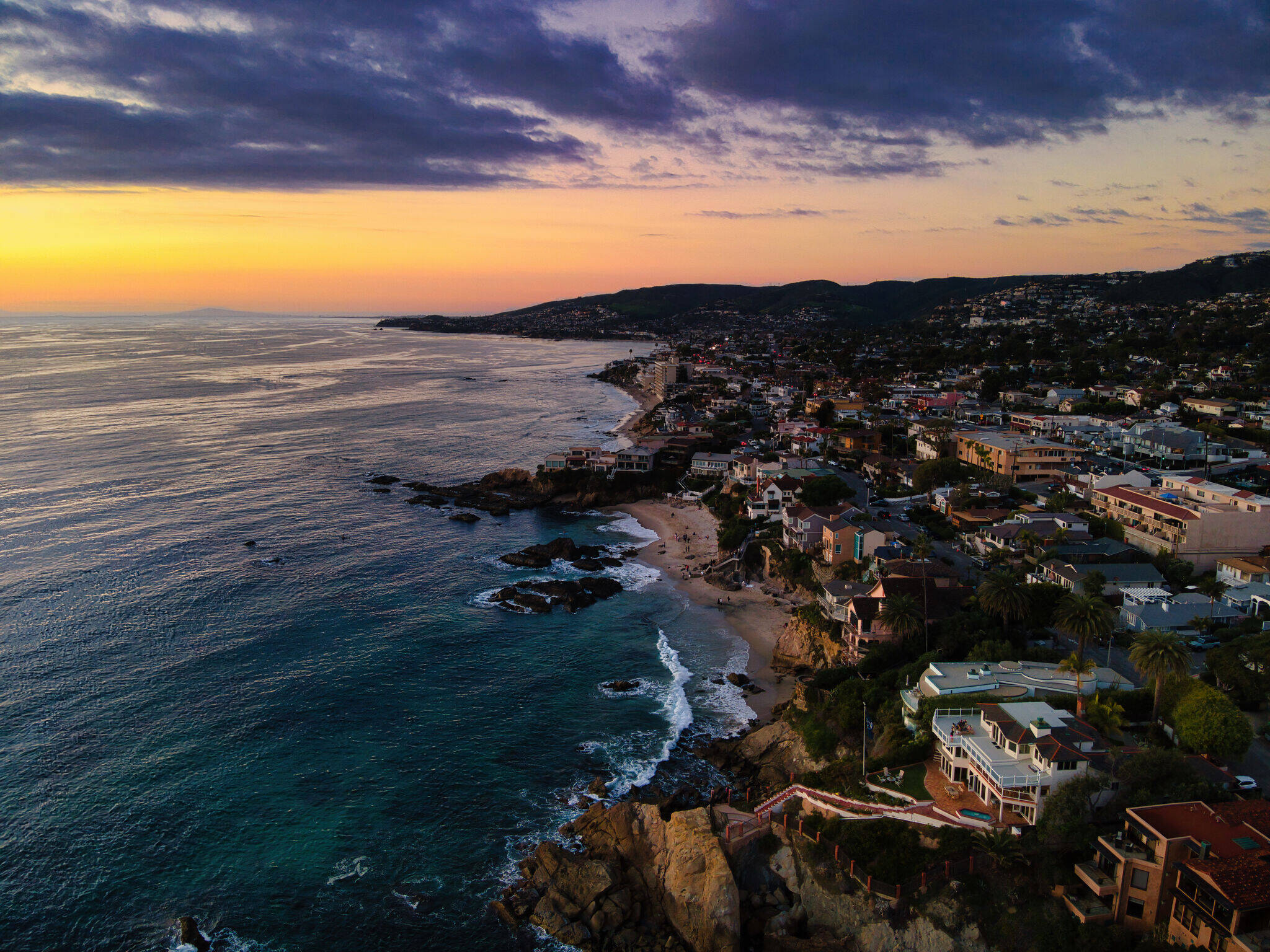 Aerial view of a coastal town and its beach at sunset