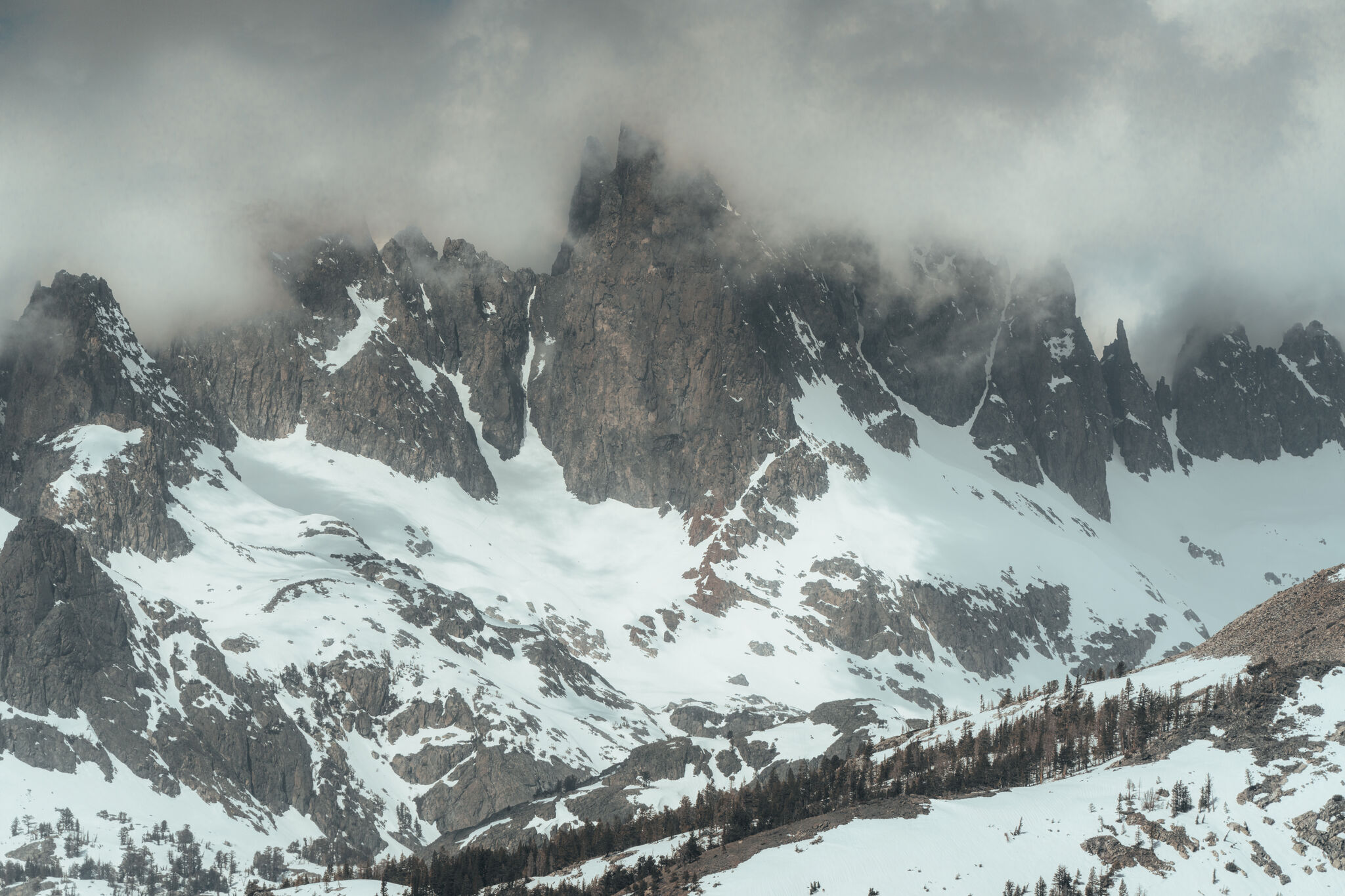 Snow-covered granite peaks wrapped in low cloud